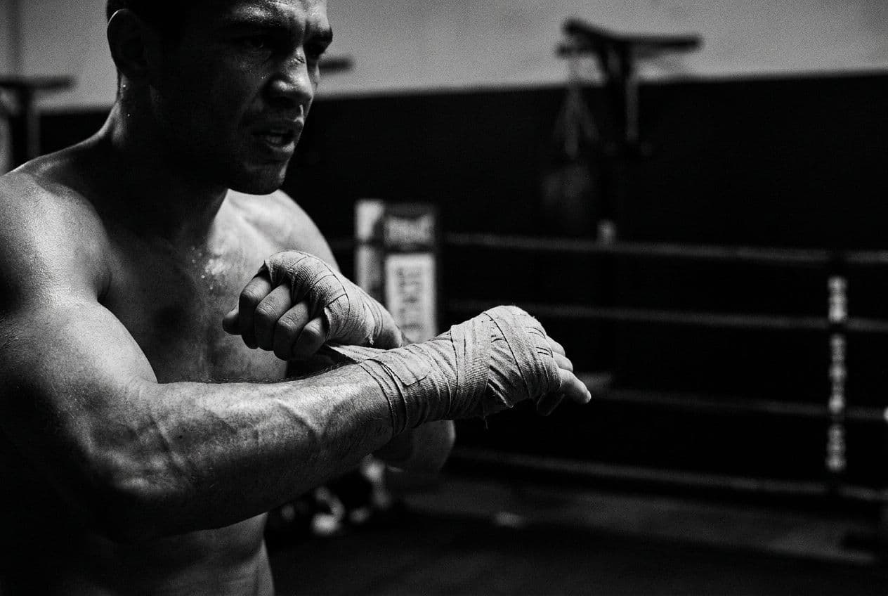 Boxeador a enrolar as mãos, o corpo a preparar-se para entrar