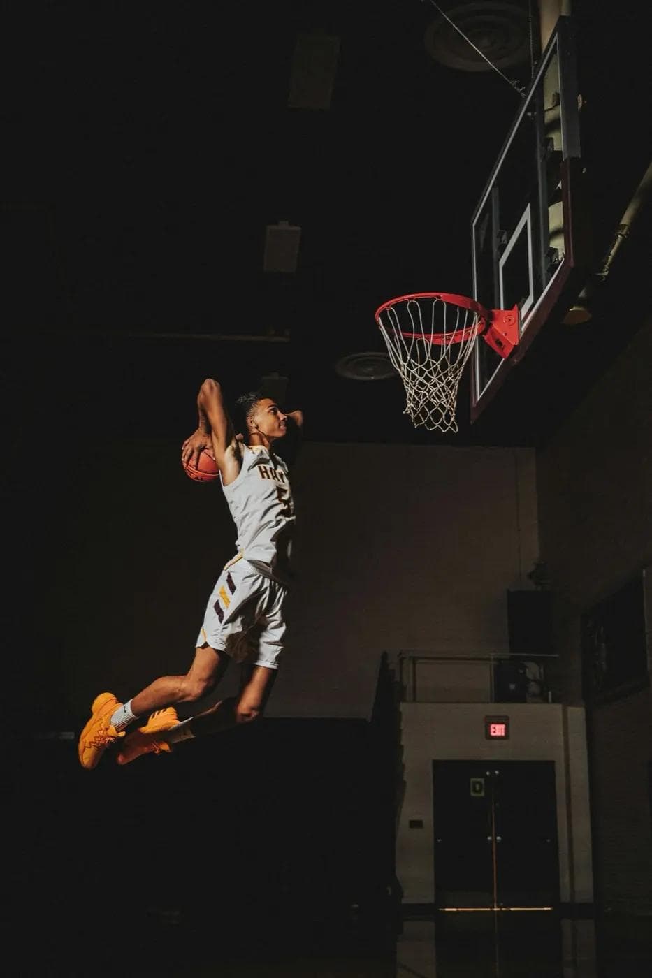 Jogador de basquetebol suspenso no ar, entre o esforço e a queda