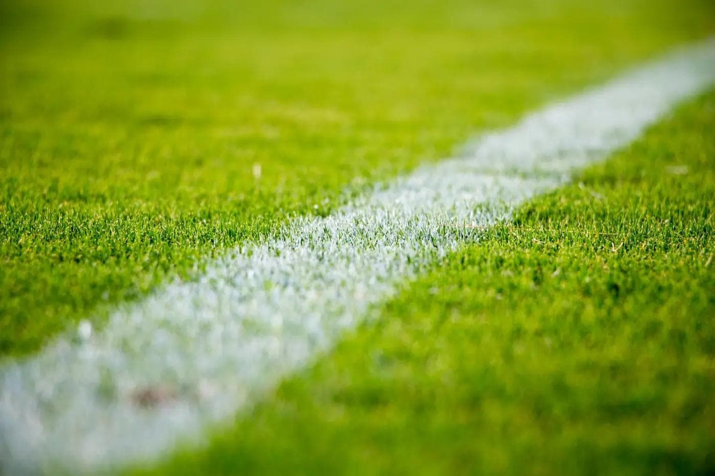 Linha branca sobre relvado, o limite claro entre dentro e fora do jogo